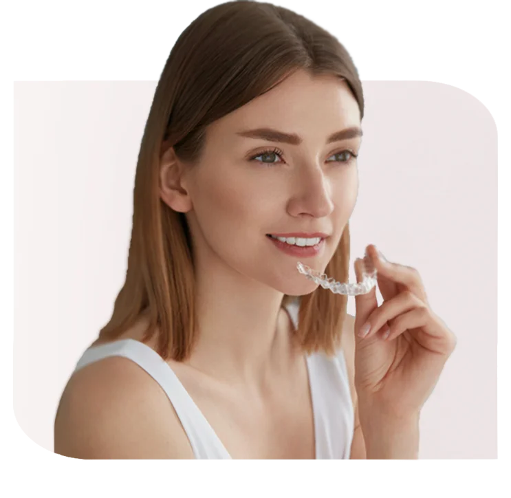 Woman holding a clear dental aligner near her teeth