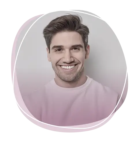 Smiling man with short dark hair wearing a pale pink sweatshirt